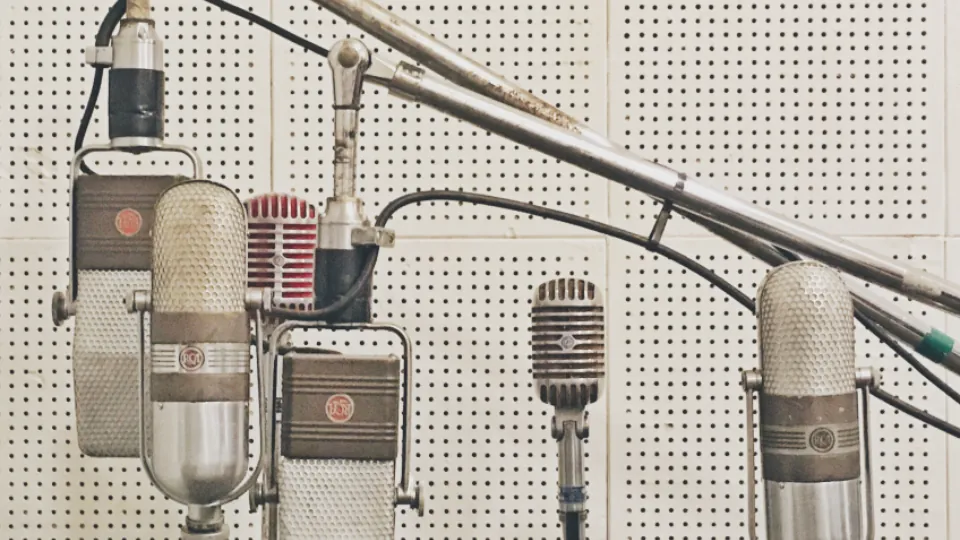 A row of vintage studio microphones in a recording booth