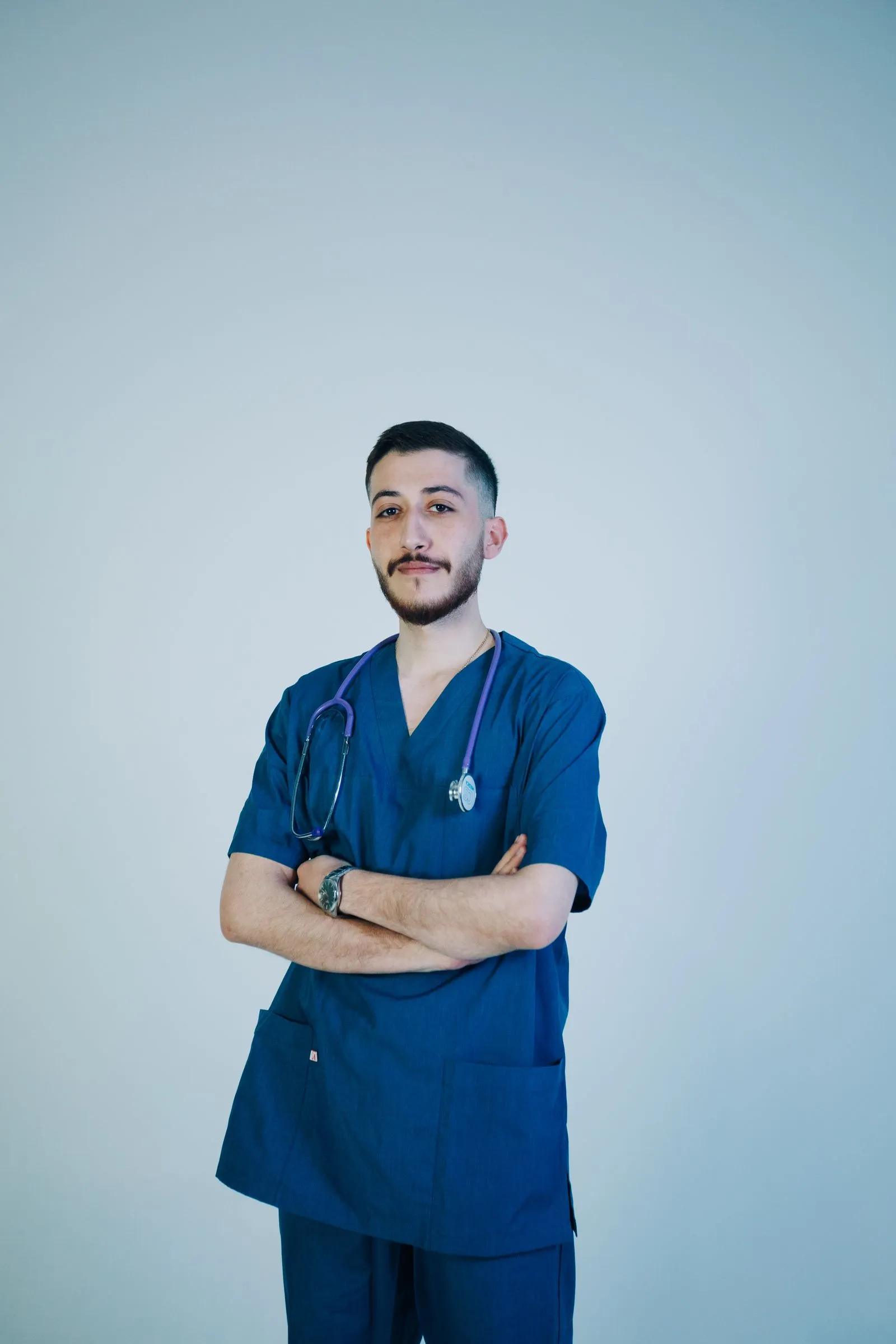 Portrait of Dr. Daniel Brooks in blue scrubs with arms crossed