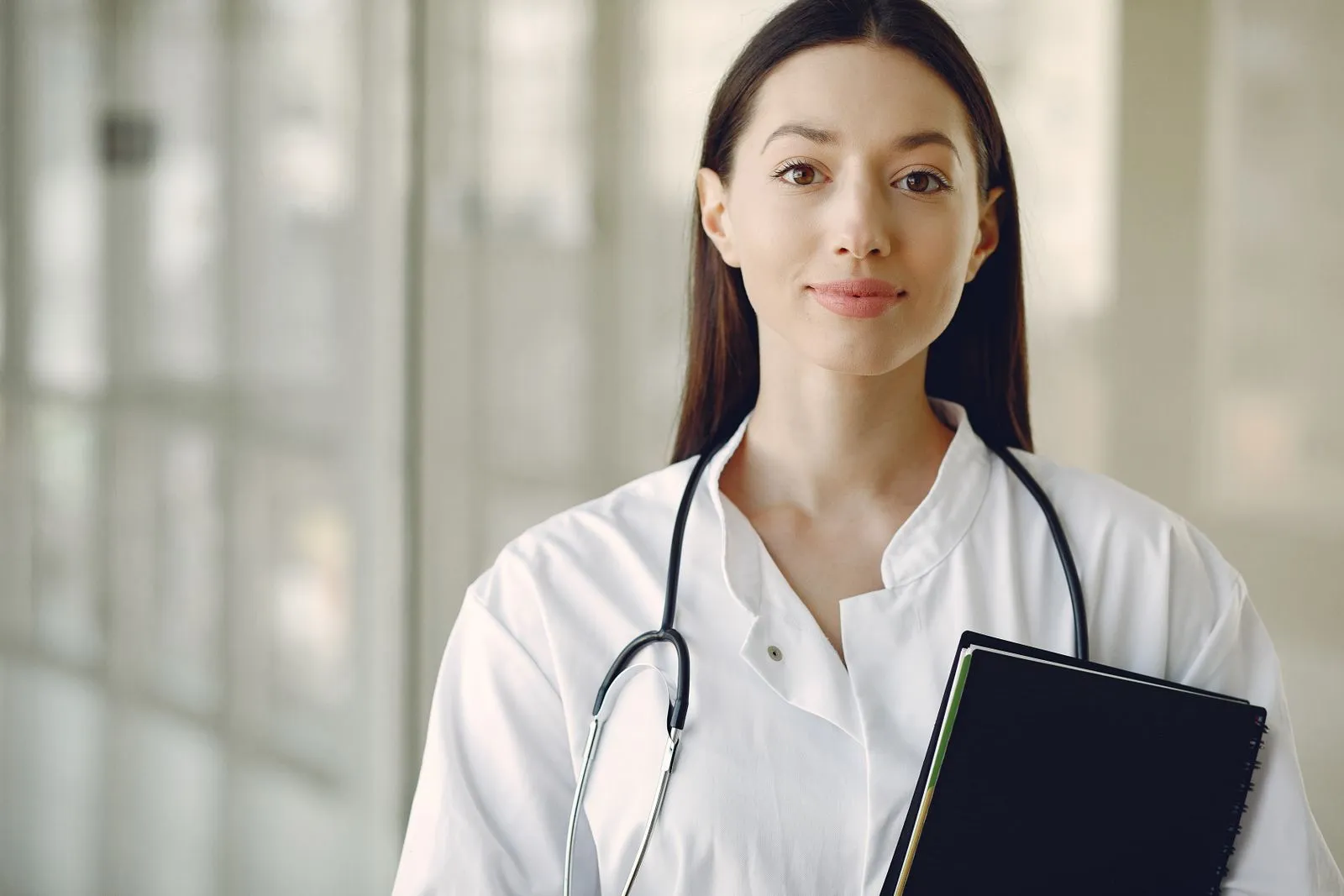 Portrait of Dr. Priya Nair with a stethoscope and clipboard