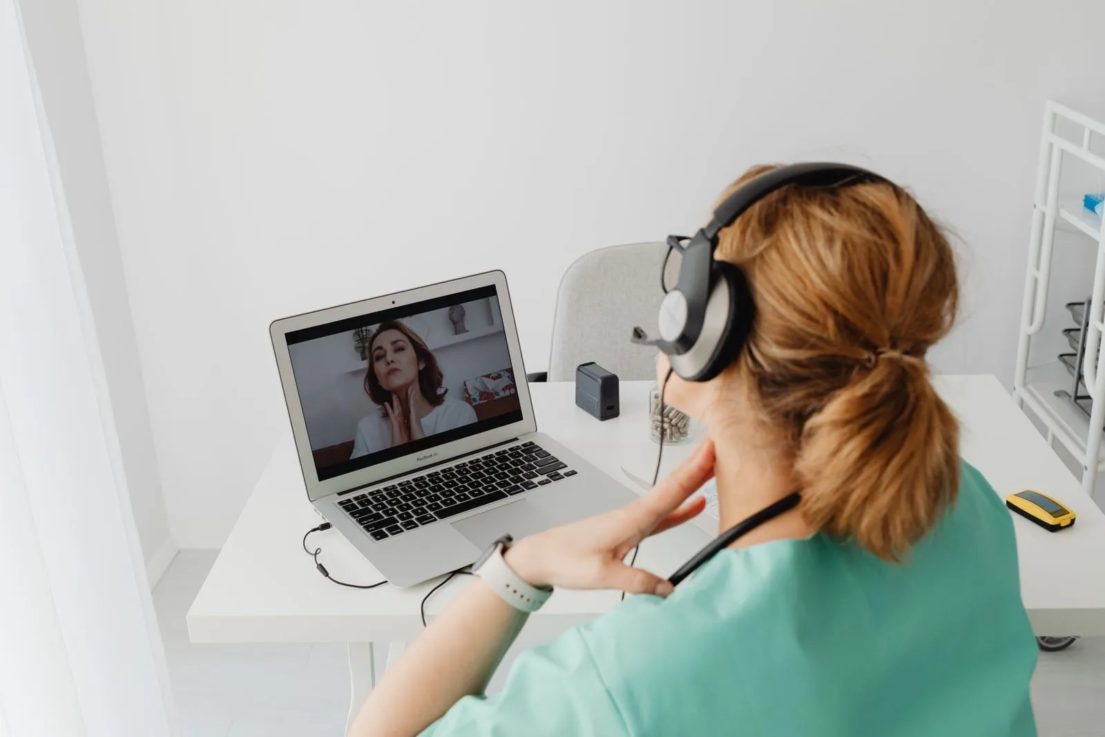 Clinician with a headset on a video call with a patient