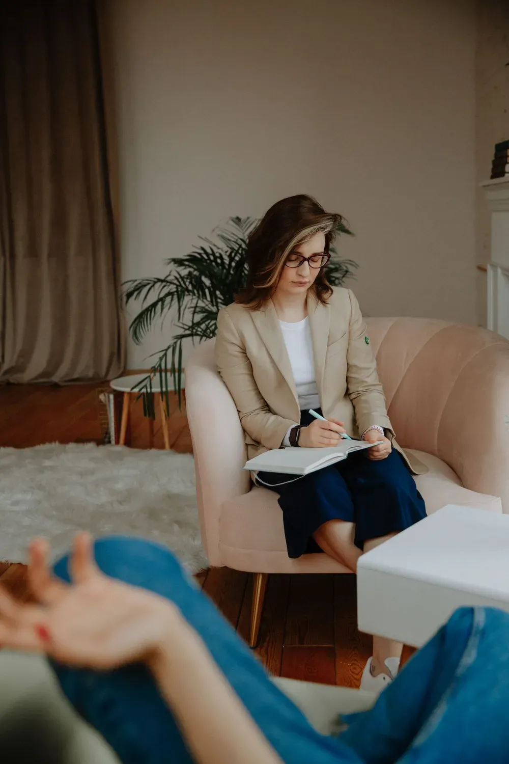 Therapist taking notes during a calm counselling session
