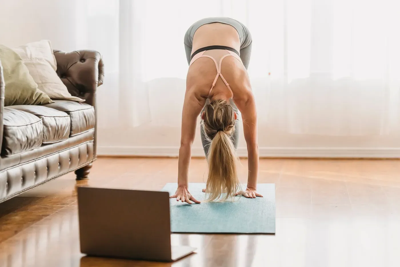 Woman following an online yoga class on a laptop at home